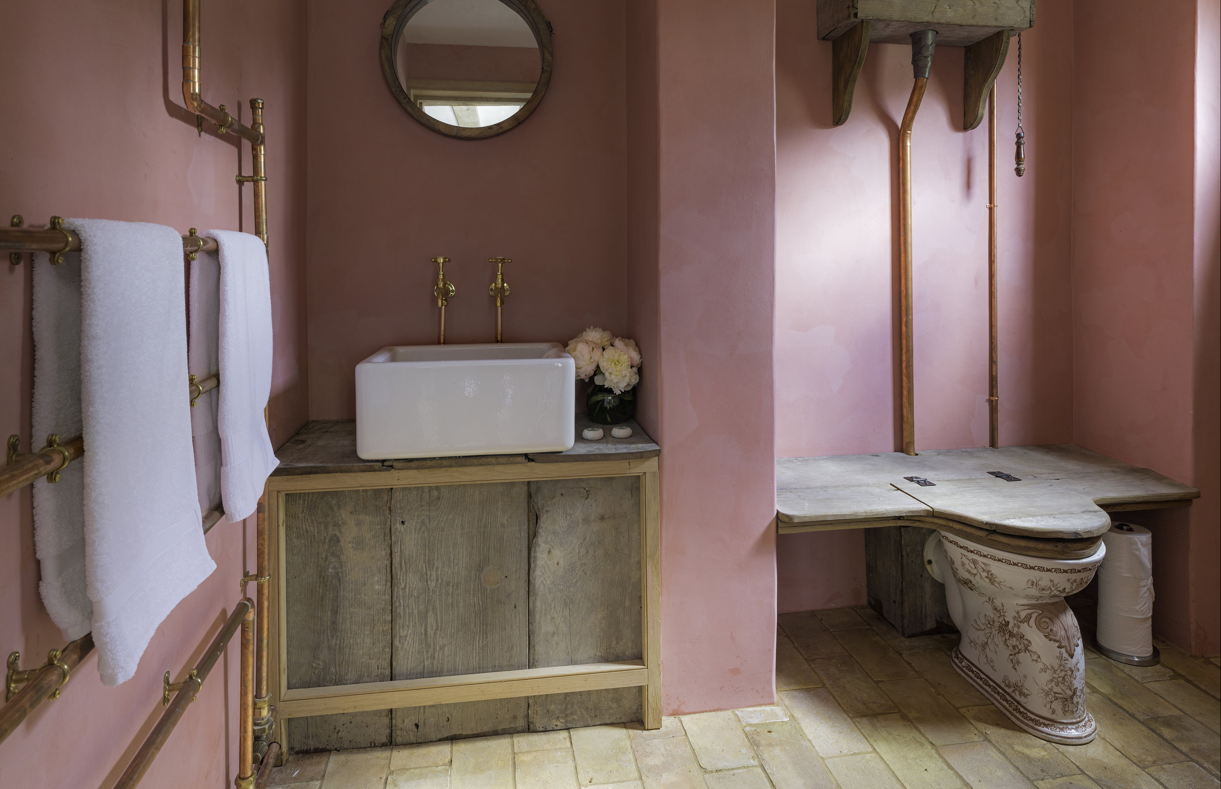 Pink, weathered wood and copper pipes combine in the Farmhouse bathroom